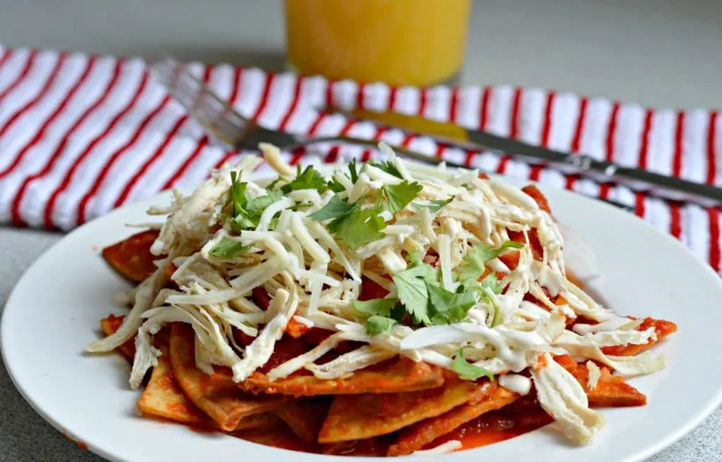 Chilaquiles made with a base of freshly cooked, homemade tortilla chips that are then submerged in a flavorful tomato and dried chile salsa, resulting in a delicious, smoky flavor.