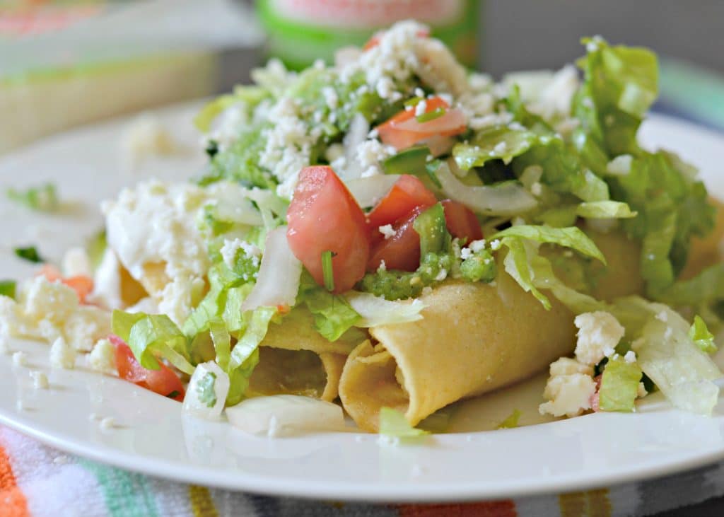 Crispy Potato Flautas are filled with creamy mashed potatoes, fried until golden brown, and topped with lettuce, pico de gallo, salsa, queso fresco and crema.