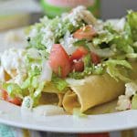 Crispy Potato Flautas are filled with creamy mashed potatoes, fried until golden brown, and topped with lettuce, pico de gallo, salsa, queso fresco and crema.