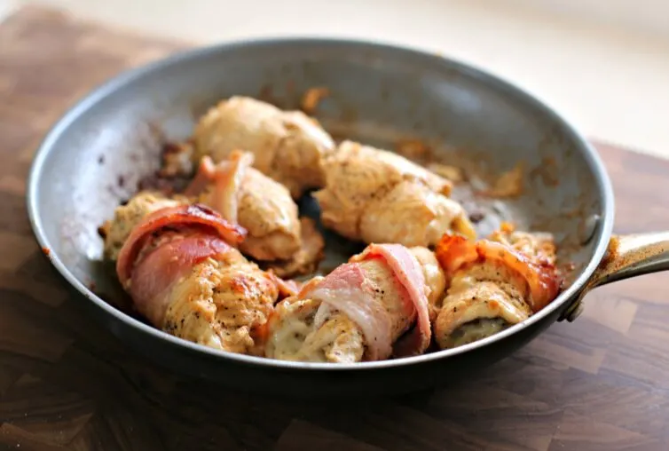 Chicken roll ups being seared before they are baked