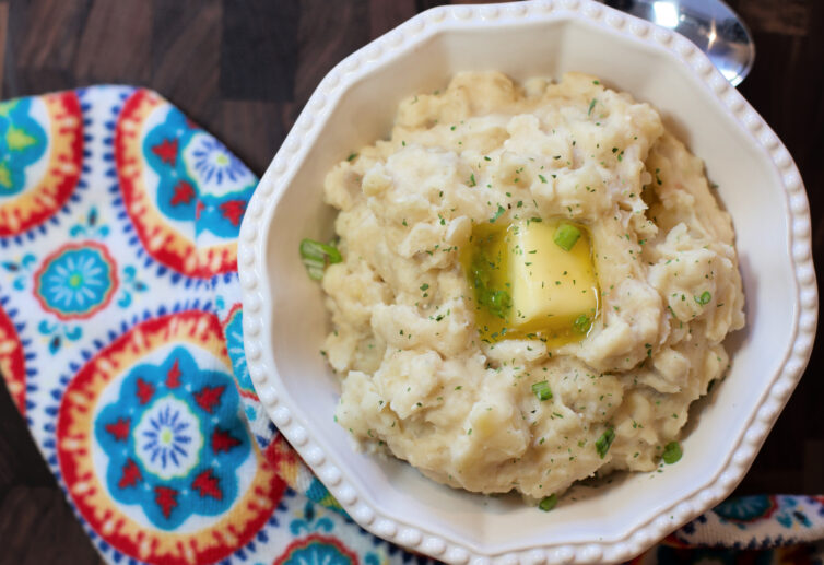 mashed potatoes in a white bowl with melted butter in the middle