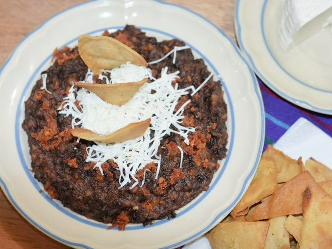 refried beans with tortilla chips, chorizo and cheese