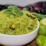 arroz verde in a white bowl with gresh ingredients next to it