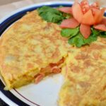 Spanish omelette with a slice cut out of it