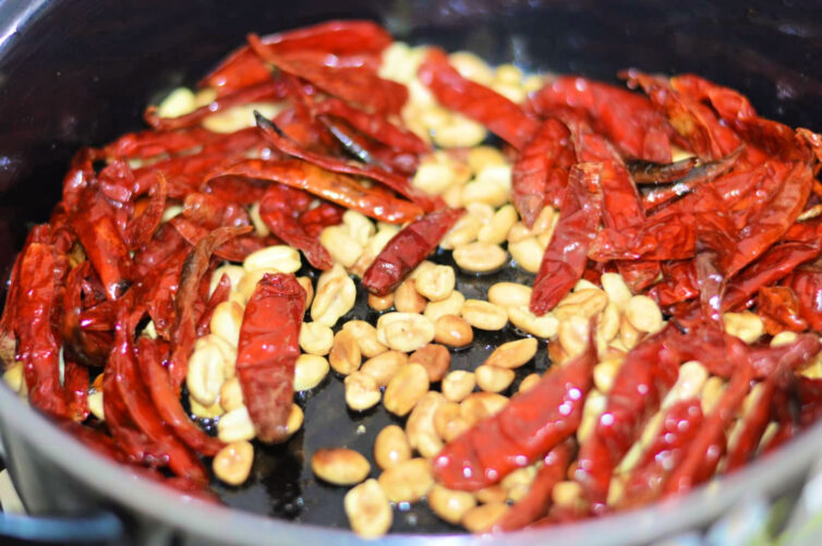 Chiles de arbol and peanuts in a skillet